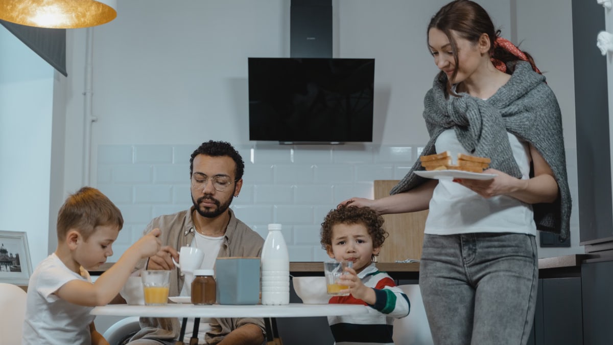 A family shares a joyful breakfast in a cozy kitchen setting, capturing a warm morning moment.